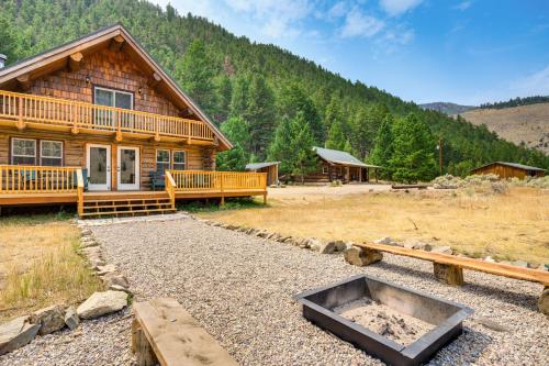 a log cabin with a large yard in front of it at Riverfront Montana Log Cabin with Mountain Views! in Melrose