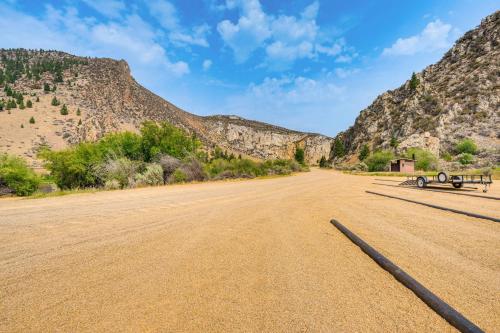 an empty road in the desert with mountains in the background at Riverfront Montana Log Cabin with Mountain Views! in Melrose