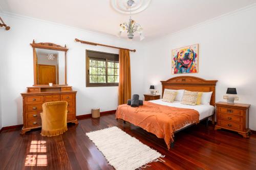 Un dormitorio con una cama, una cómoda y un espejo. en Villa Rocio, en Illes Balears