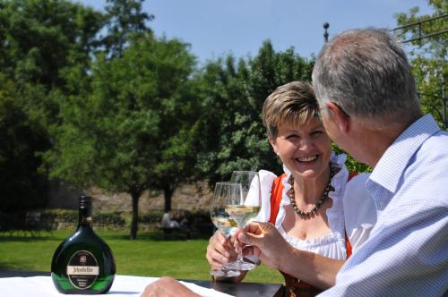 a man and a woman holding a glass of wine at Romantik Hotel Zehntkeller in Iphofen