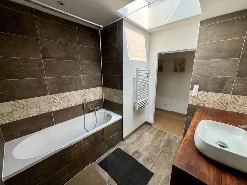 a bathroom with a bath tub and a sink at La villa des Épicuriens - Arès - Bassin d'Arcachon in Arès