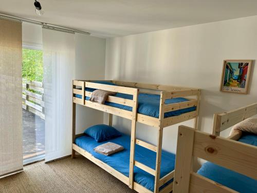 two bunk beds in a room with a window at La villa des Épicuriens - Arès - Bassin d'Arcachon in Arès