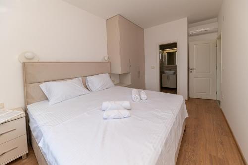 a bedroom with a white bed with two towels on it at Red Hill in Kotor