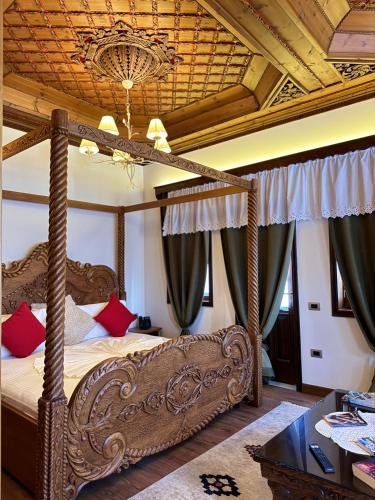 a bedroom with a canopy bed with a wooden ceiling at KERCULLA Resort in Gjirokastër