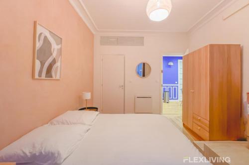- une chambre avec un grand lit blanc et une armoire dans l'établissement Flexliving - room - Neuilly-sur-Seine, à Neuilly-sur-Seine