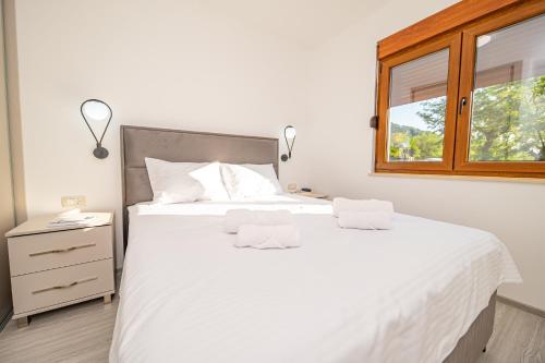 a bedroom with a large white bed with a window at Red Hill in Kotor