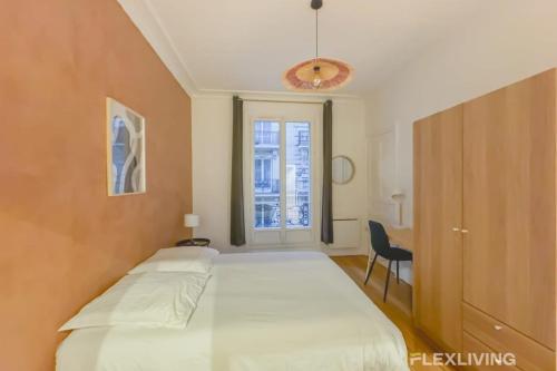 une chambre avec un grand lit blanc et une fenêtre dans l'établissement Flexliving - room - Neuilly-sur-Seine, à Neuilly-sur-Seine