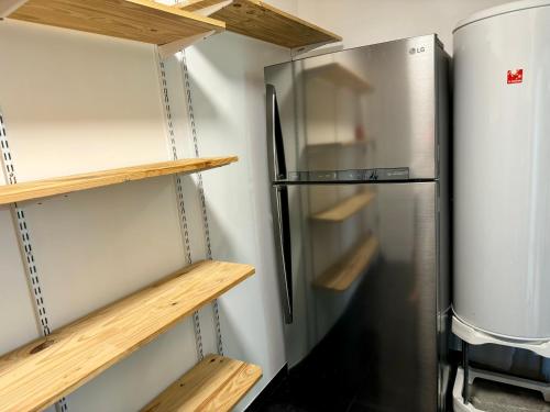 a refrigerator in a kitchen with wooden shelves at La villa des Épicuriens - Arès - Bassin d'Arcachon in Arès