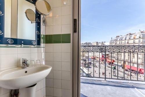 ein Bad mit einem Waschbecken und Stadtblick in der Unterkunft Avenir Hotel Montmartre in Paris