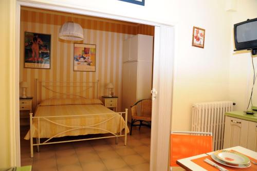 フォッローニカにあるResidence Il Soleのベッドルーム(ベッド1台、テーブル、テレビ付)