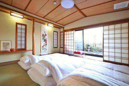 a bedroom with two beds in a room with a window at 錦糸町徒歩4分210平米大空間和風庭園テラススカイツリービュー畳部屋 in Tokyo