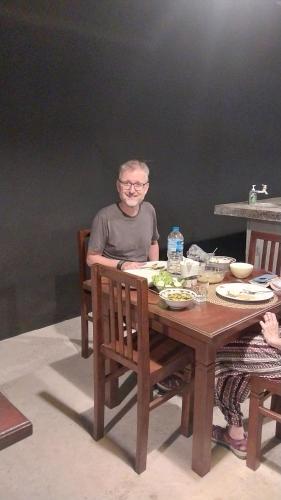 a man sitting at a table with a plate of food at Hotel white house mahiyanganaya in Mahiyangana