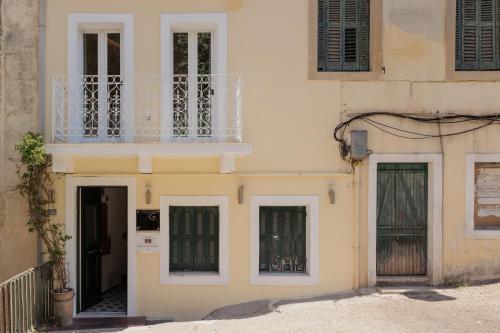 a white building with a balcony and a door at Celestial Suites-TOP LOCATION in Corfu Town