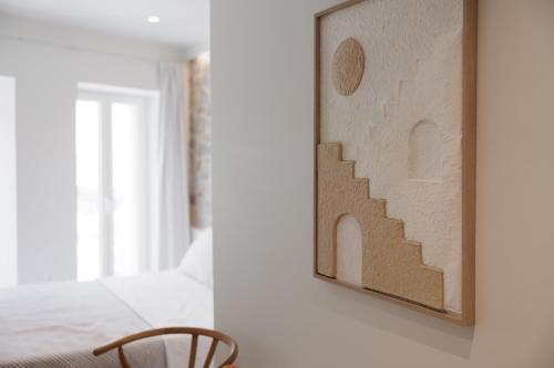 a bedroom with a painting of stairs on the wall at Celestial Suites-TOP LOCATION in Corfu Town