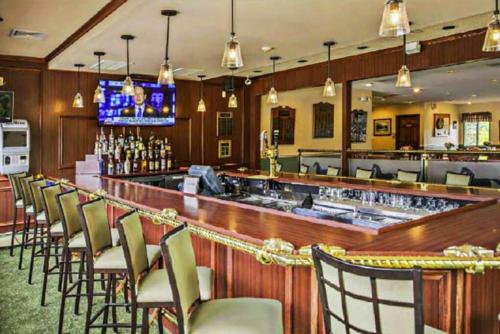 a bar in a restaurant with chairs and a counter at The Beautiful & Cozy Malvec Chalet in Tobyhanna