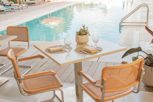 a table and chairs next to a swimming pool at MB Hotel, Trademark Collection by Wyndham in Miami Beach