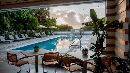 a patio with tables and chairs and a swimming pool at MB Hotel, Trademark Collection by Wyndham in Miami Beach