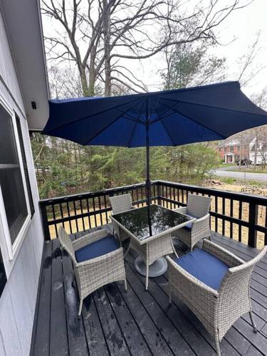 a patio with a table and chairs and an umbrella at The Beautiful & Cozy Malvec Chalet in Tobyhanna