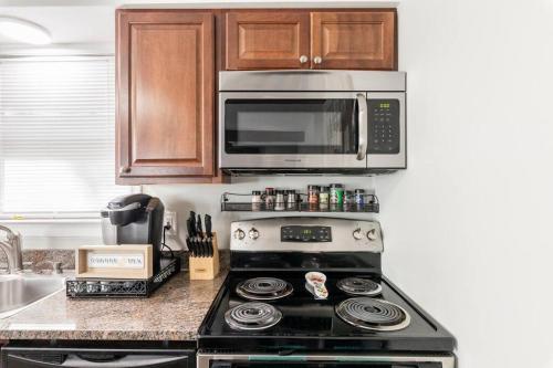 a kitchen with a stove and a microwave at The Beautiful & Cozy Malvec Chalet in Tobyhanna
