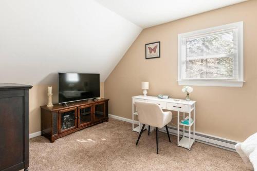 a living room with a television and a table and a chair at The Beautiful & Cozy Malvec Chalet in Tobyhanna
