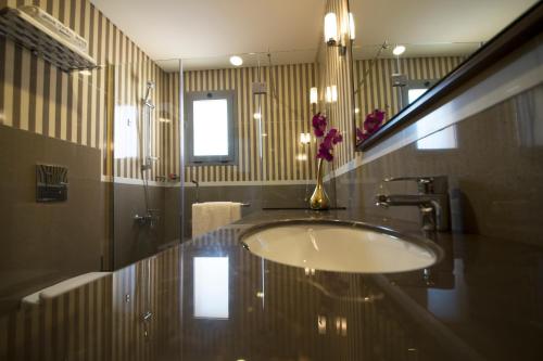 a bathroom with a sink and a vase of flowers at Urban Central Suites - Beirut in Beirut
