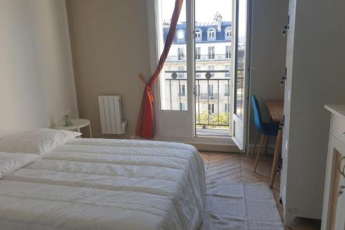 une chambre avec un lit et une grande fenêtre dans l'établissement Flexliving - room - Voltaire, à Paris