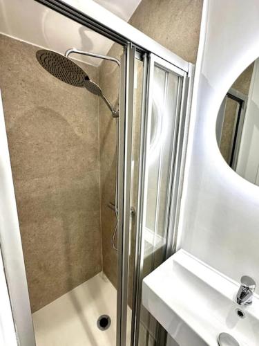 une salle de bain avec une douche avec un lavabo et un miroir dans l'établissement Lovely 3BR 3BA 3WC with Terrace, à Cannes