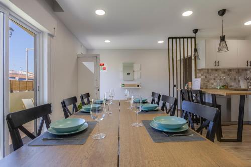 a dining room with a long table with blue plates and glasses at Refúgio do Cabo in Sagres