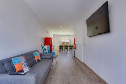 a living room with a couch and a flat screen tv at Refúgio do Cabo in Sagres