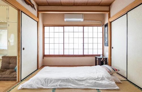 a large bed in a room with a large window at 板東ビル in Tokyo