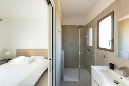 une salle de bain avec un lit, une douche et un lavabo dans l'établissement Villa avec piscine, à Ghisonaccia