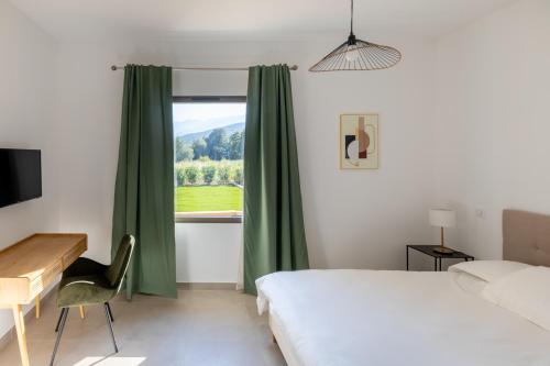 une chambre avec un lit, un bureau et une fenêtre dans l'établissement Villa avec piscine, à Ghisonaccia