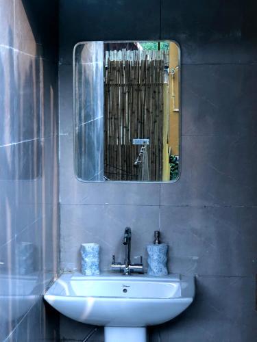 a bathroom with a sink and a mirror at Bell Glamping by The HULYA since 2021 in Mukteshwar
