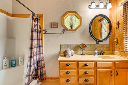 un baño con lavabo y espejo en Cabin on Table Rock Lake with Hot Tub and Fire Pit!, en Blue Eye