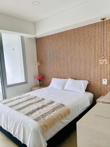 a bedroom with a large bed with a wooden wall at Apartamento en Cartagena in Cartagena de Indias