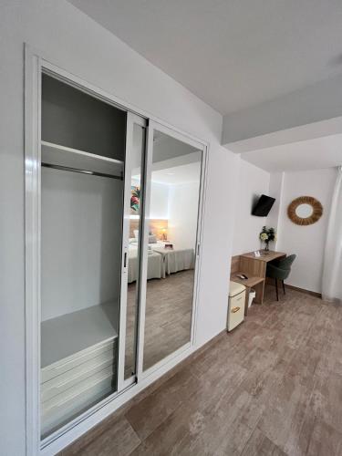a room with a sliding glass door with a bedroom at Hotel Romerito in Málaga