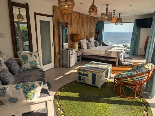 a living room with a bed and a view of the ocean at Beachwood Camps Bay in Cape Town