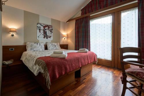a bedroom with a bed and a large window at Hotel Walser Courmayeur in Courmayeur