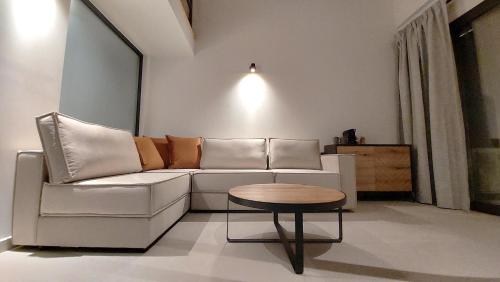a living room with a white couch and a table at Eros and Psyche Suites in Nydri