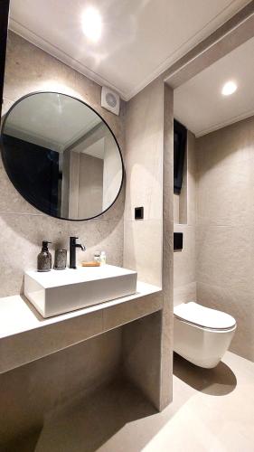 a bathroom with a sink and a mirror and a toilet at Eros and Psyche Suites in Nydri