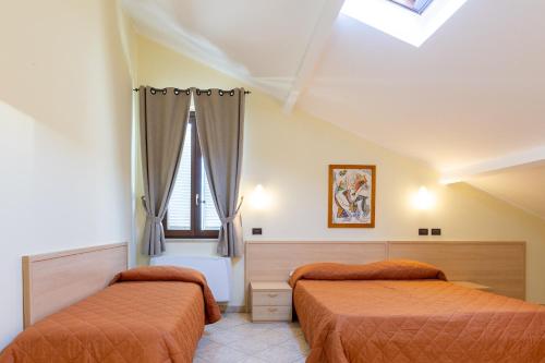 a bedroom with two beds and a window at Locanda dei 4 in Narni