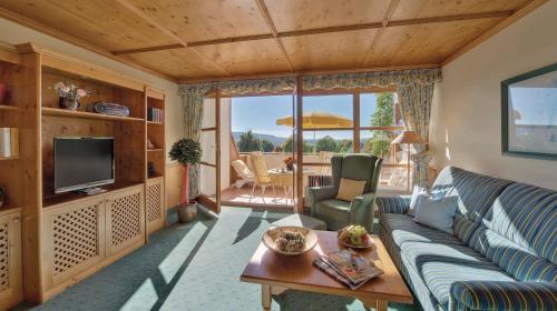 a living room with a couch and a tv at Apart Hotel am Sonnenhügel in Bad Birnbach