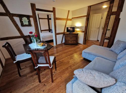 a living room with a couch and a table at Hotel & Café Mohrenbrunnen in Eisenberg