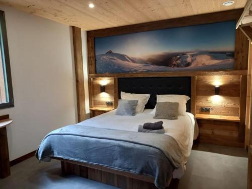 une chambre avec un grand lit avec un tableau au mur dans l'établissement Superbe Chalet avec piscine secteur Gérardmer, à Liézey