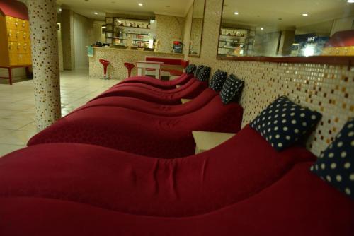 a row of red couches sitting in a room at Kivrak Hotel in Antalya