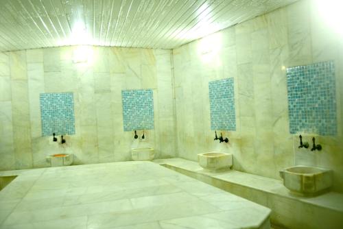a large bathroom with two urinals and two sinks at Kivrak Hotel in Antalya