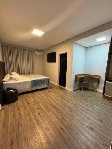 a bedroom with a bed and a desk in it at Hotel Diamante in Sao Paulo
