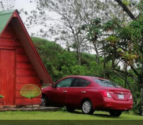 a red car parked next to a red shed at Sunset Inn in Fortuna