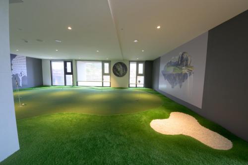 a room with a green floor with a clock on the wall at 宜蘭頭城A Happy Birthday 私人溫泉 海景 蘭陽夜景大陽台無邊際泳池 in Toucheng