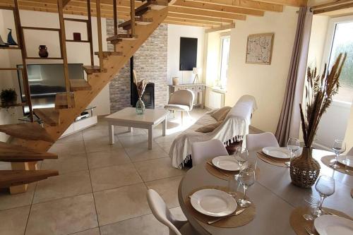 un salon avec un canapé et une table avec des chaises dans l'établissement Gîte de bord de mer, Le Calicoco, à Gatteville-le-Phare